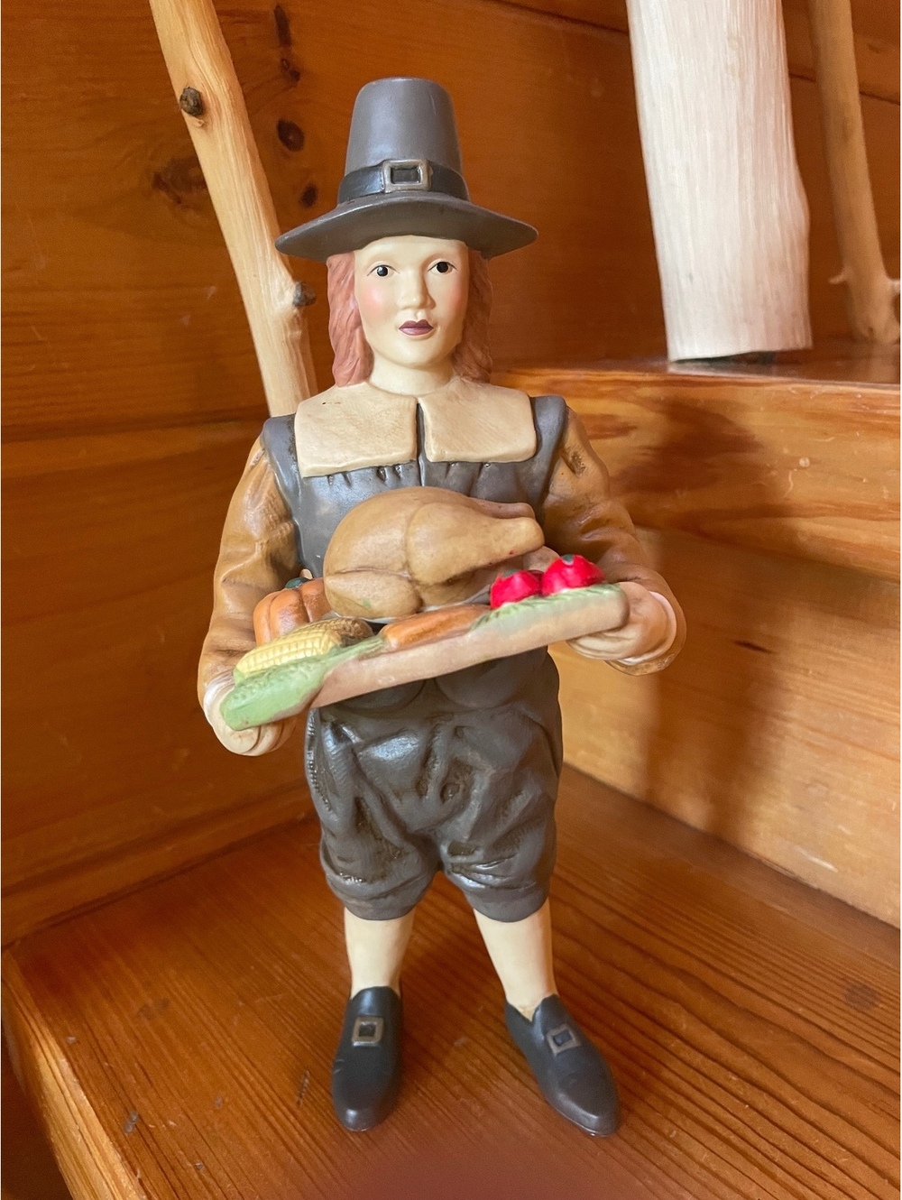 Pilgrim figurine holding bread and apples